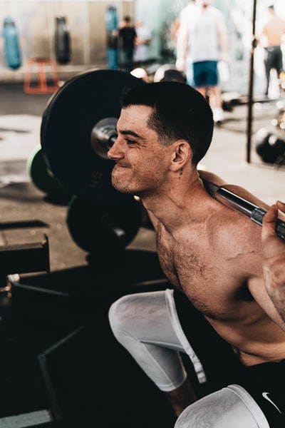 Topless man in white shorts with smartphones
